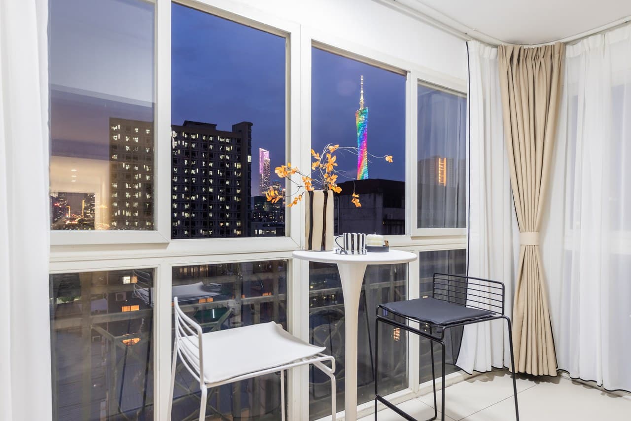 Panoramic floor-to-ceiling windows offer stunning views of the Canton Tower at night.