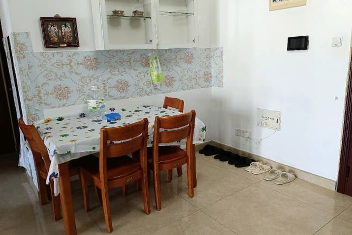 The living room has a sofa. There is also an extra bed. The dining room has a dining table.