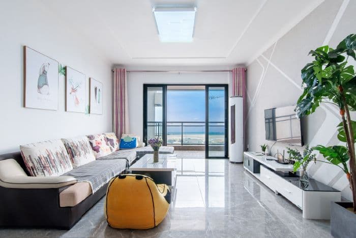 The spacious and bright living room offers a view of the blue sea.